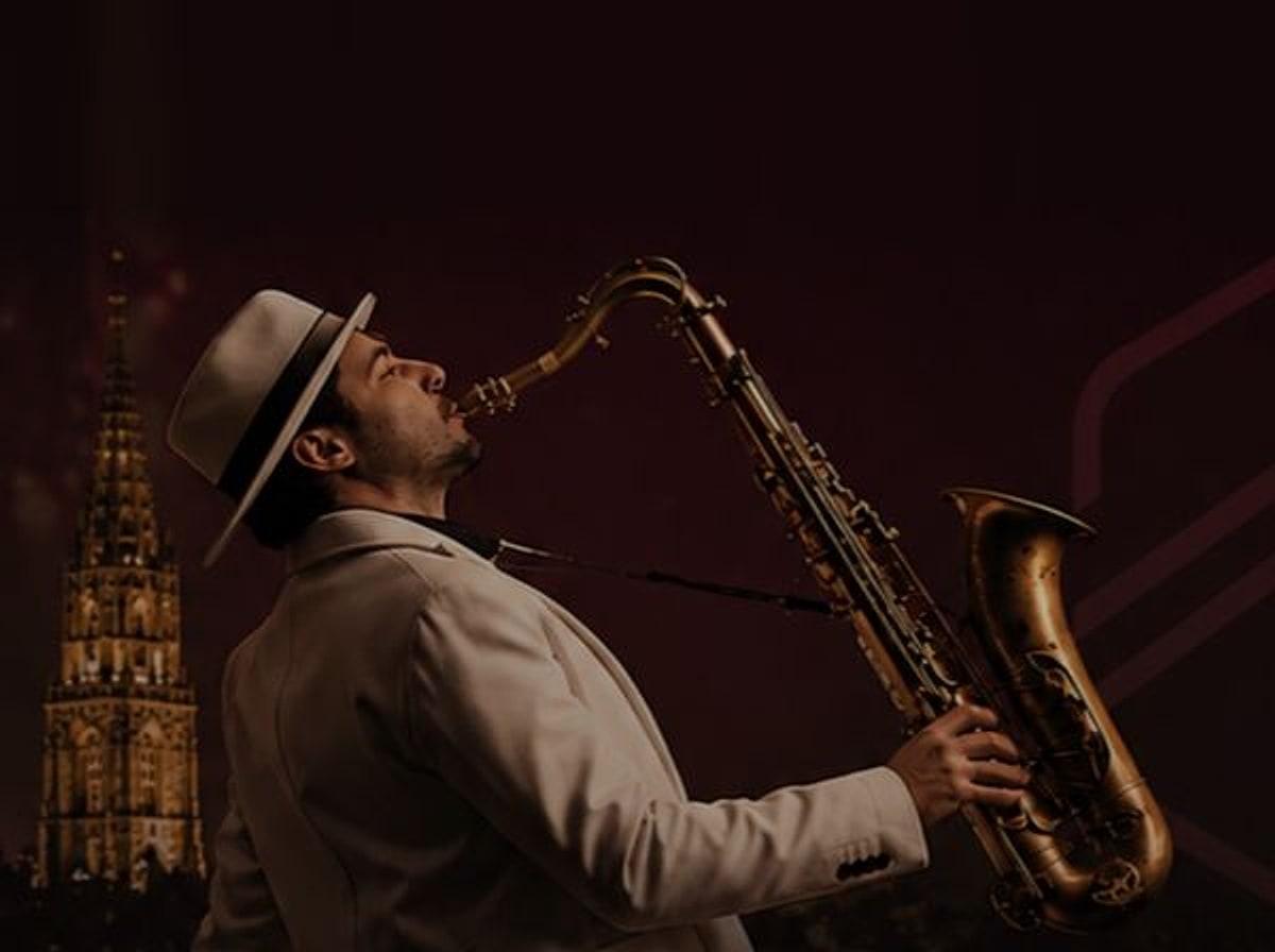 Daniele Vitale am Saxophon vor der nächtlichen Silhouette von Bern