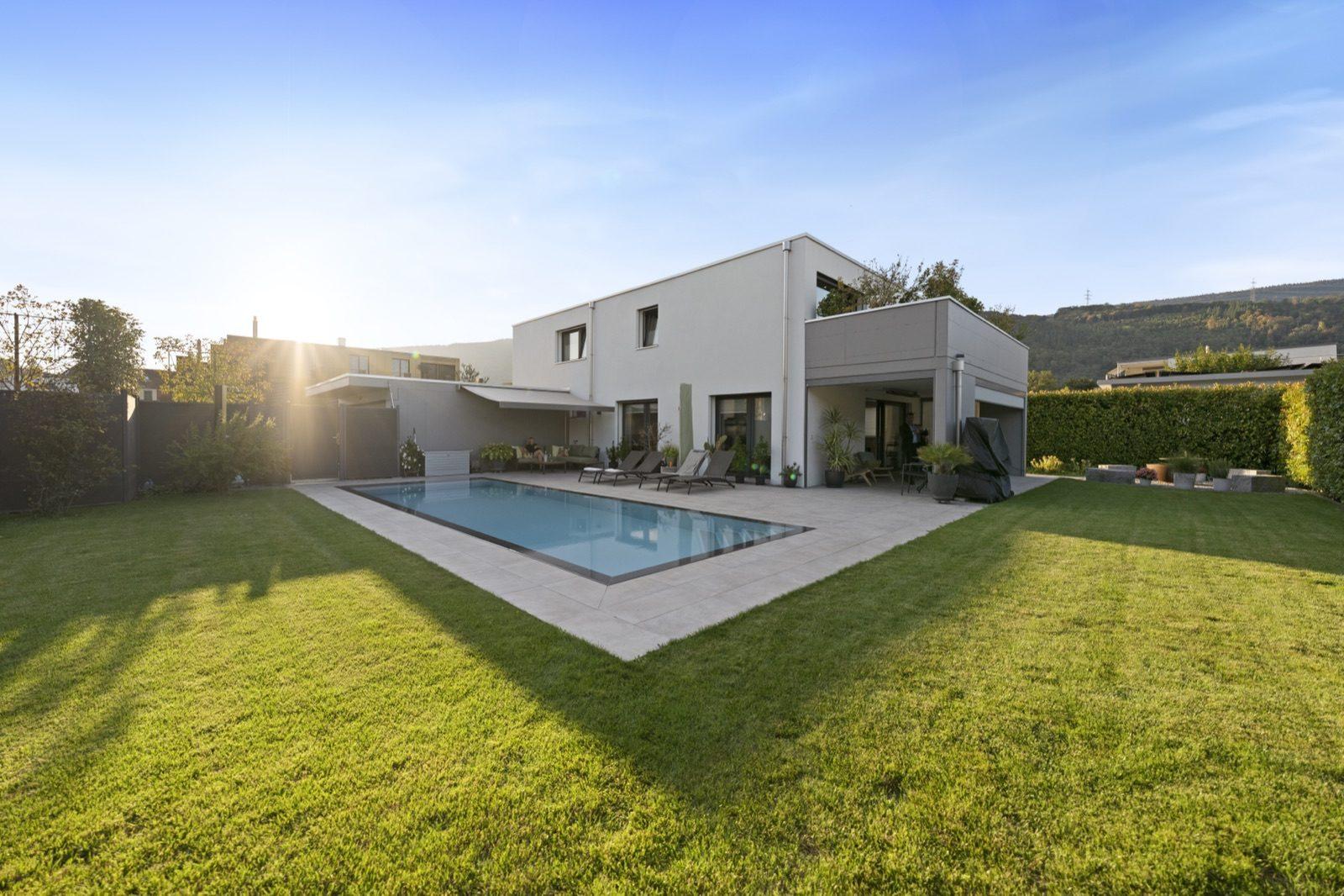 Modernes Wohnhaus mit Pool und Garten im Abendlicht