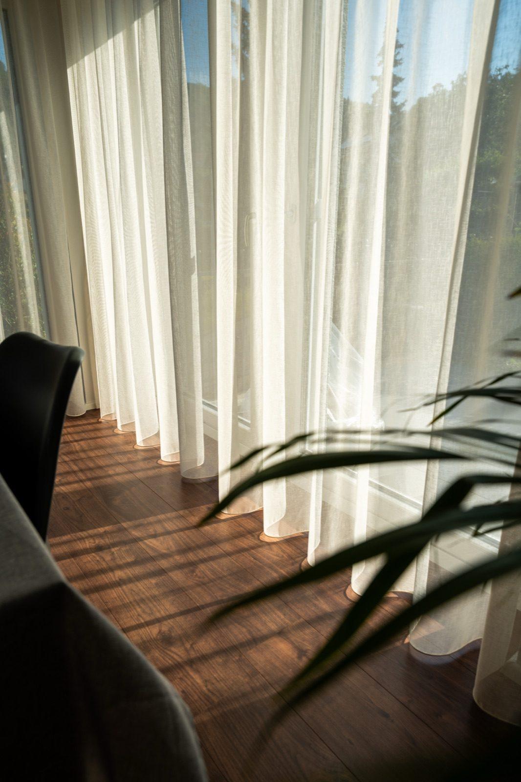 Sonnenlicht durch Vorhänge auf Parkett