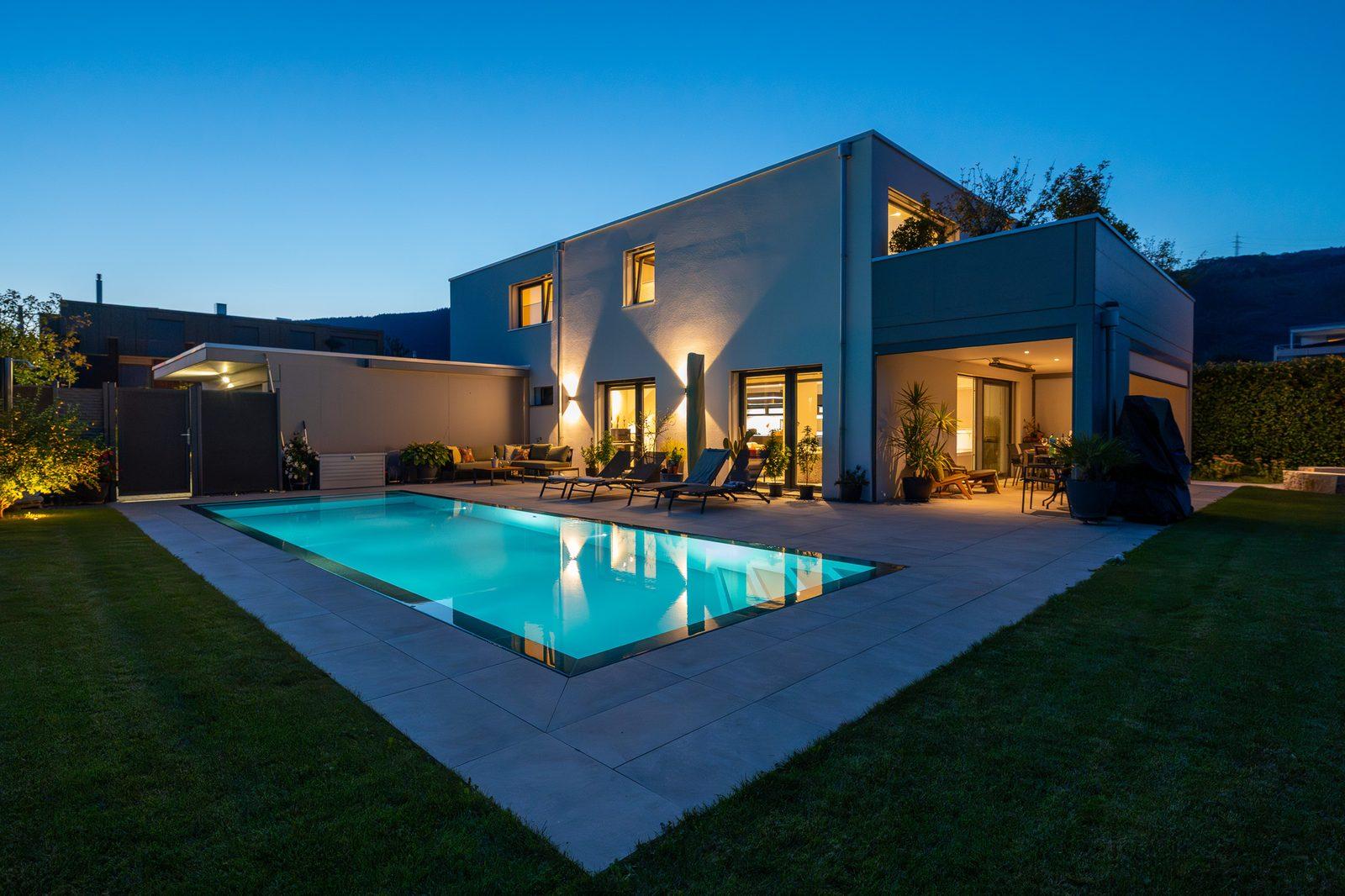 Villa mit beleuchtetem Pool in der blauen Stunde